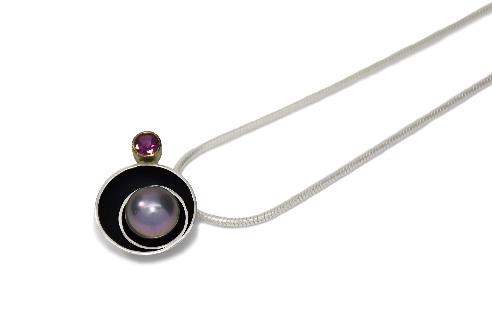 A handmade sterling silver and pearl planet pendant with silver chain