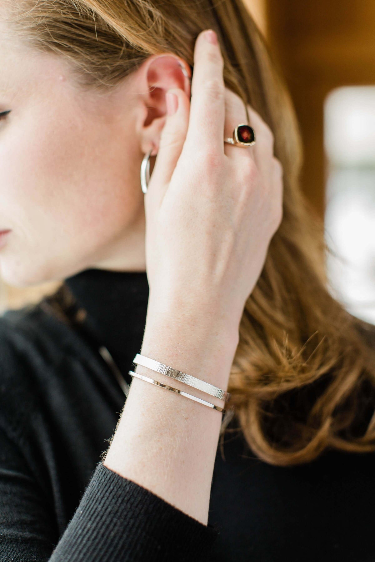 A model wears a handmade sterling silver hammered cuff bracelet