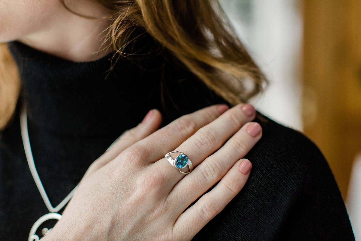 A model wears a double twist ring in sterling silver with Swiss blue topaz gemstone