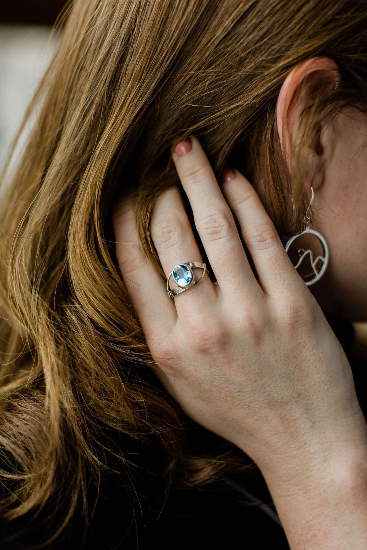 A model wears a double twist ring with gemstone in white gold