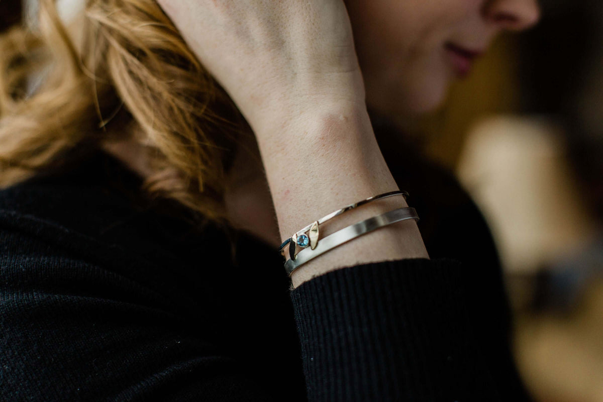 a model wears a yellow gold version of our rose gold leaf bracelet