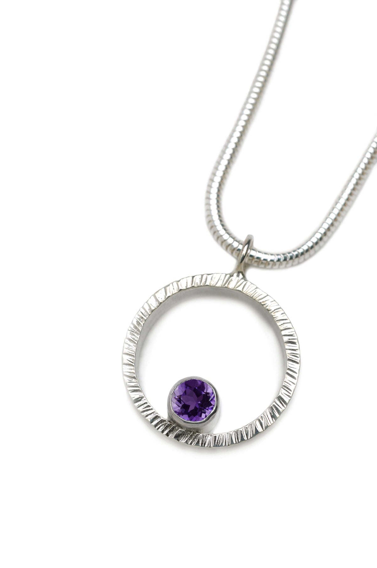 A hammered circle pendant necklace with amethyst