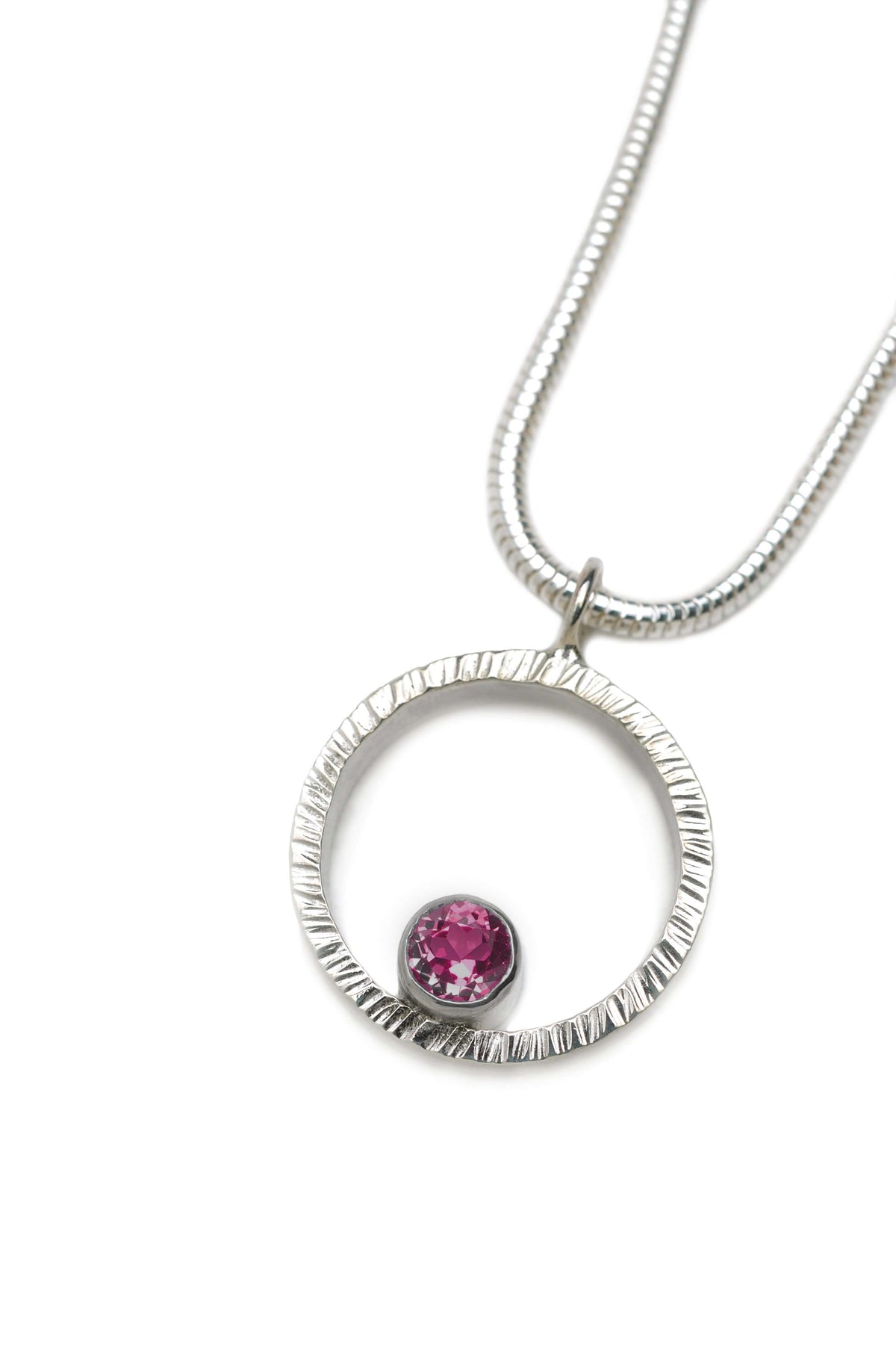 A hammered circle pendant necklace with garnet