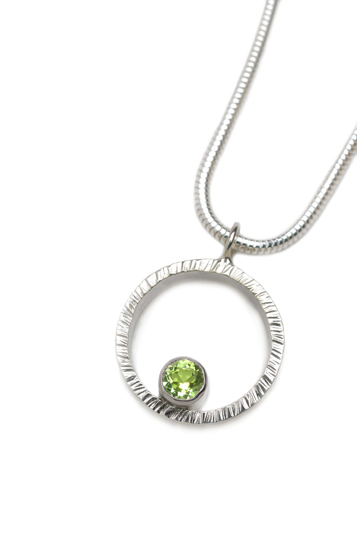 A hammered circle pendant necklace with Peridot
