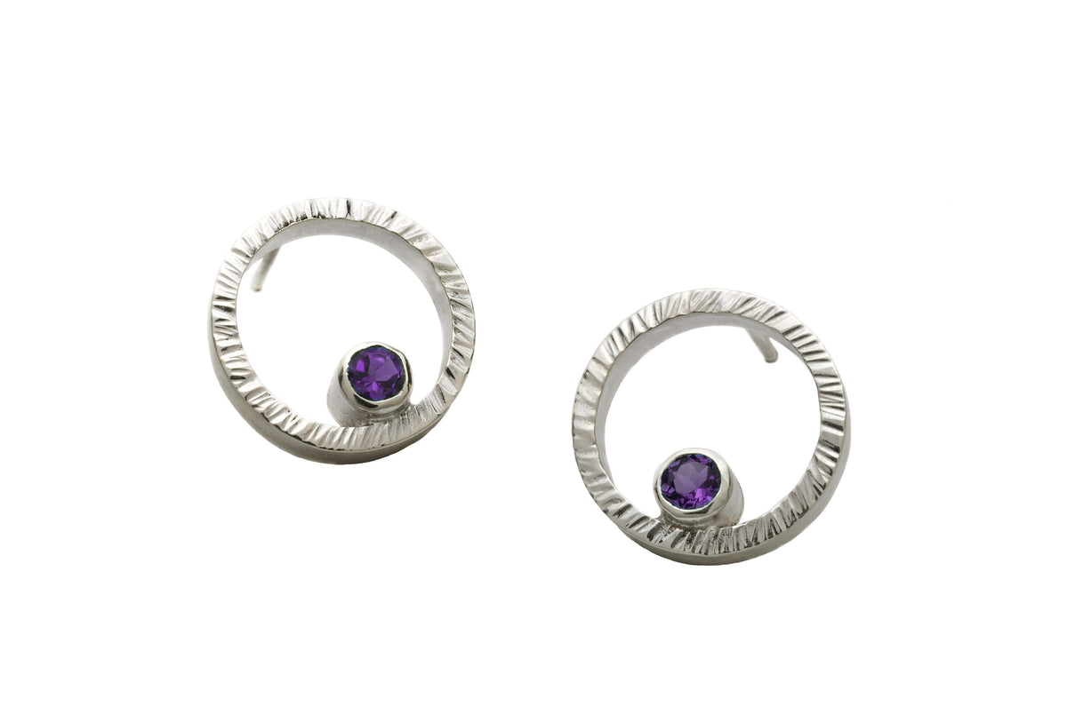 A pair of sterling silver circle studs with amethyst