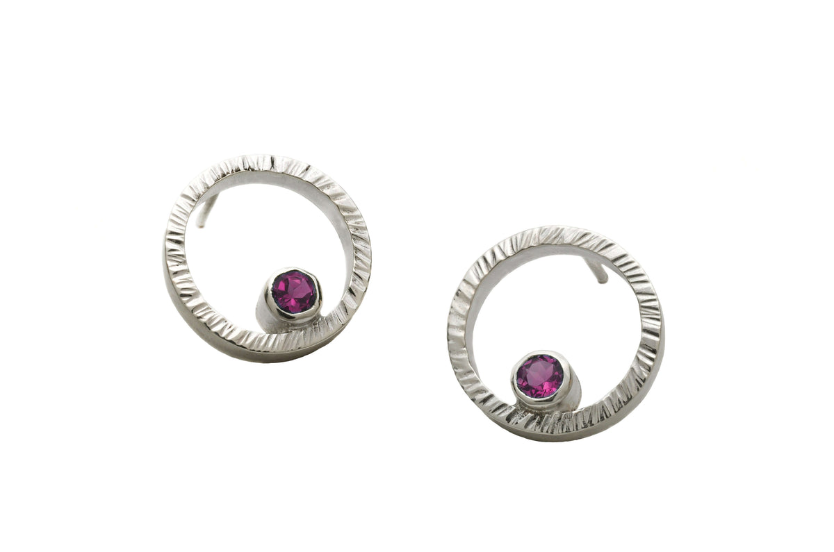 A pair of sterling silver circle studs with garnet