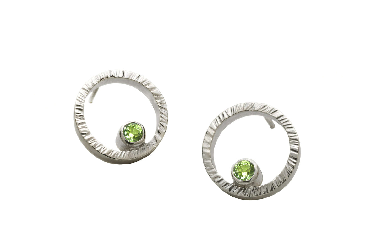 A pair of sterling silver circle studs with peridot