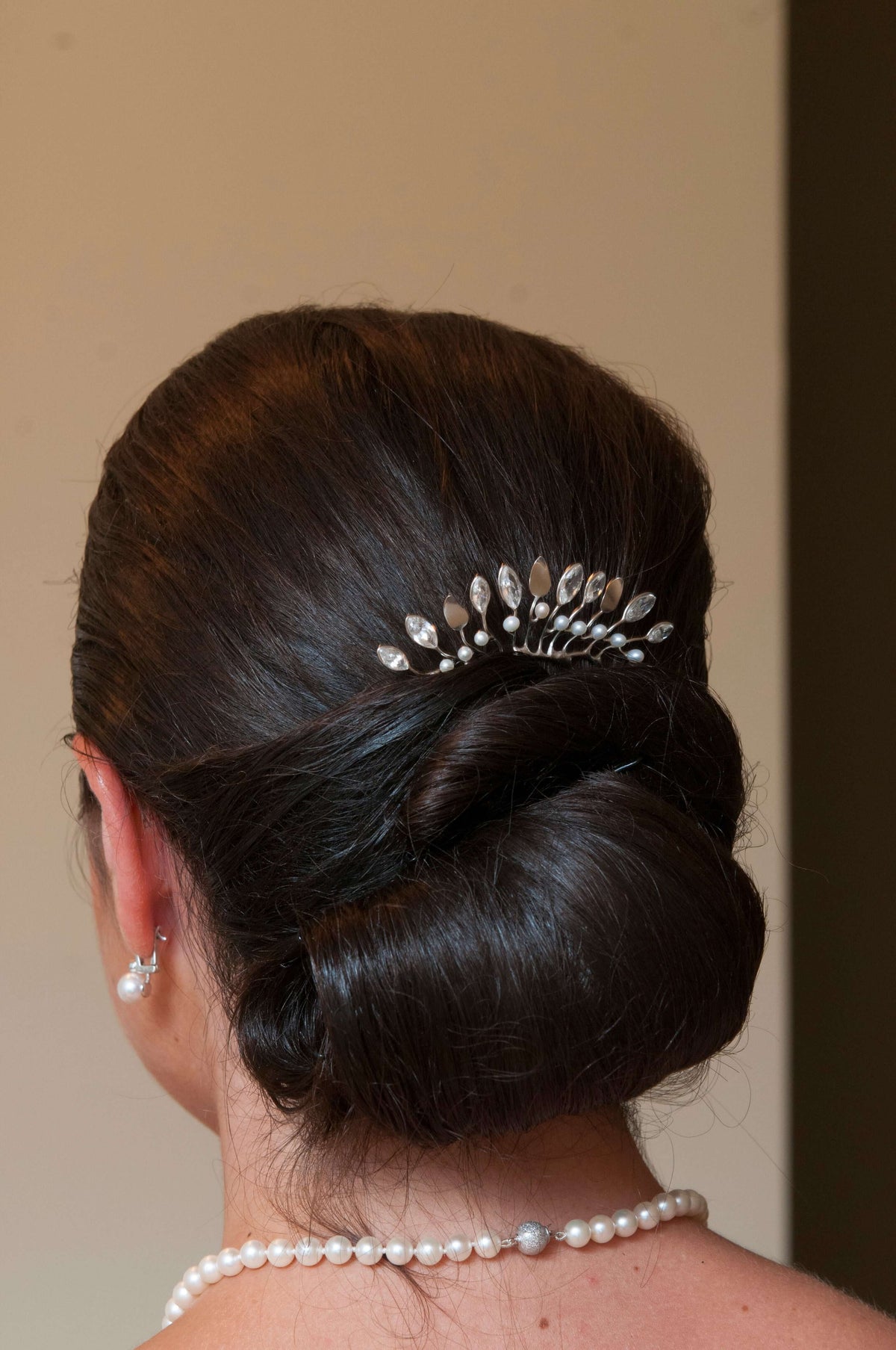 A bride wears a sterling silver leaf hair comb with cubic zirconia and freshwater pearls
