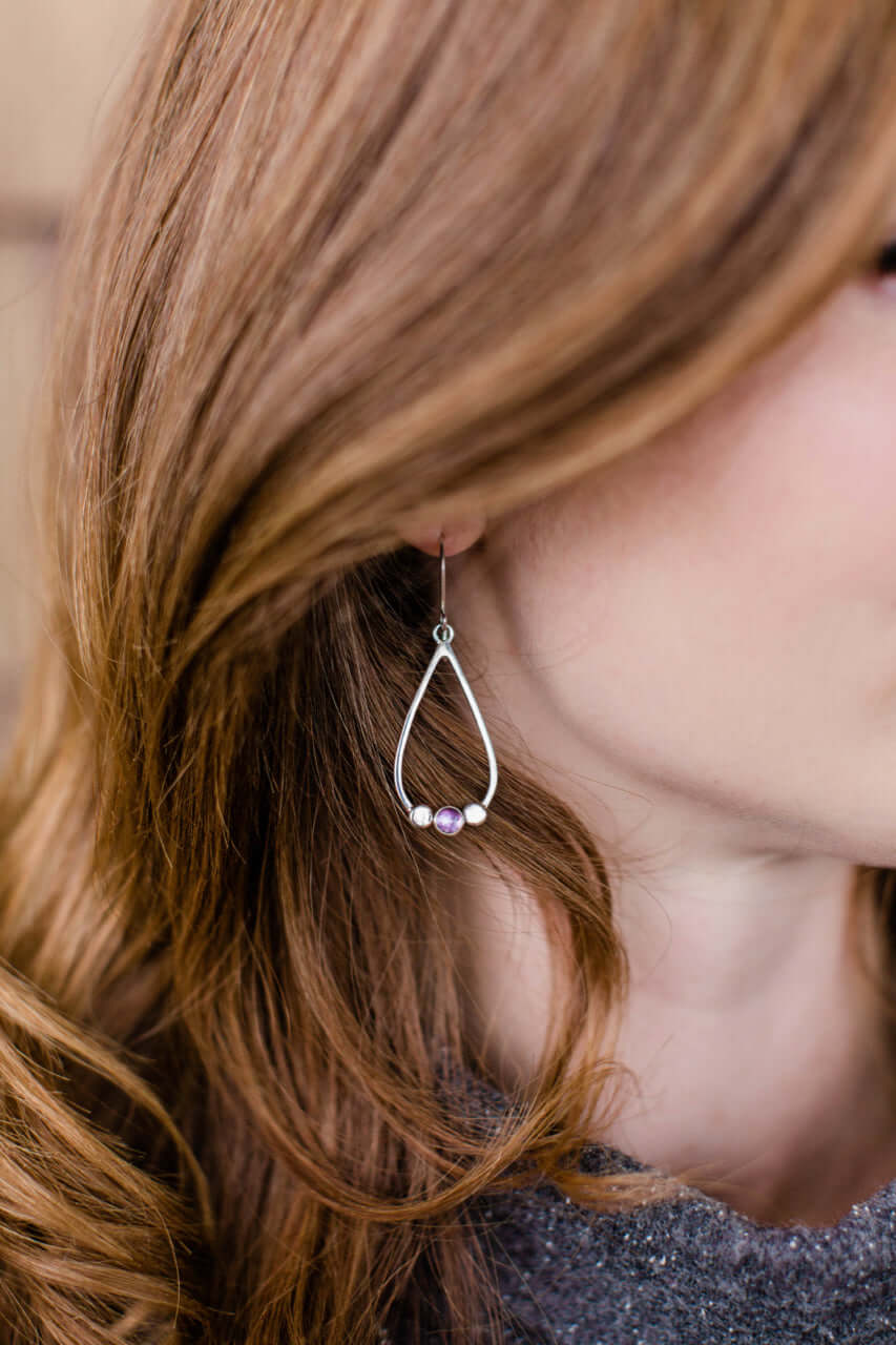 A model wears garnet drop earrings silver