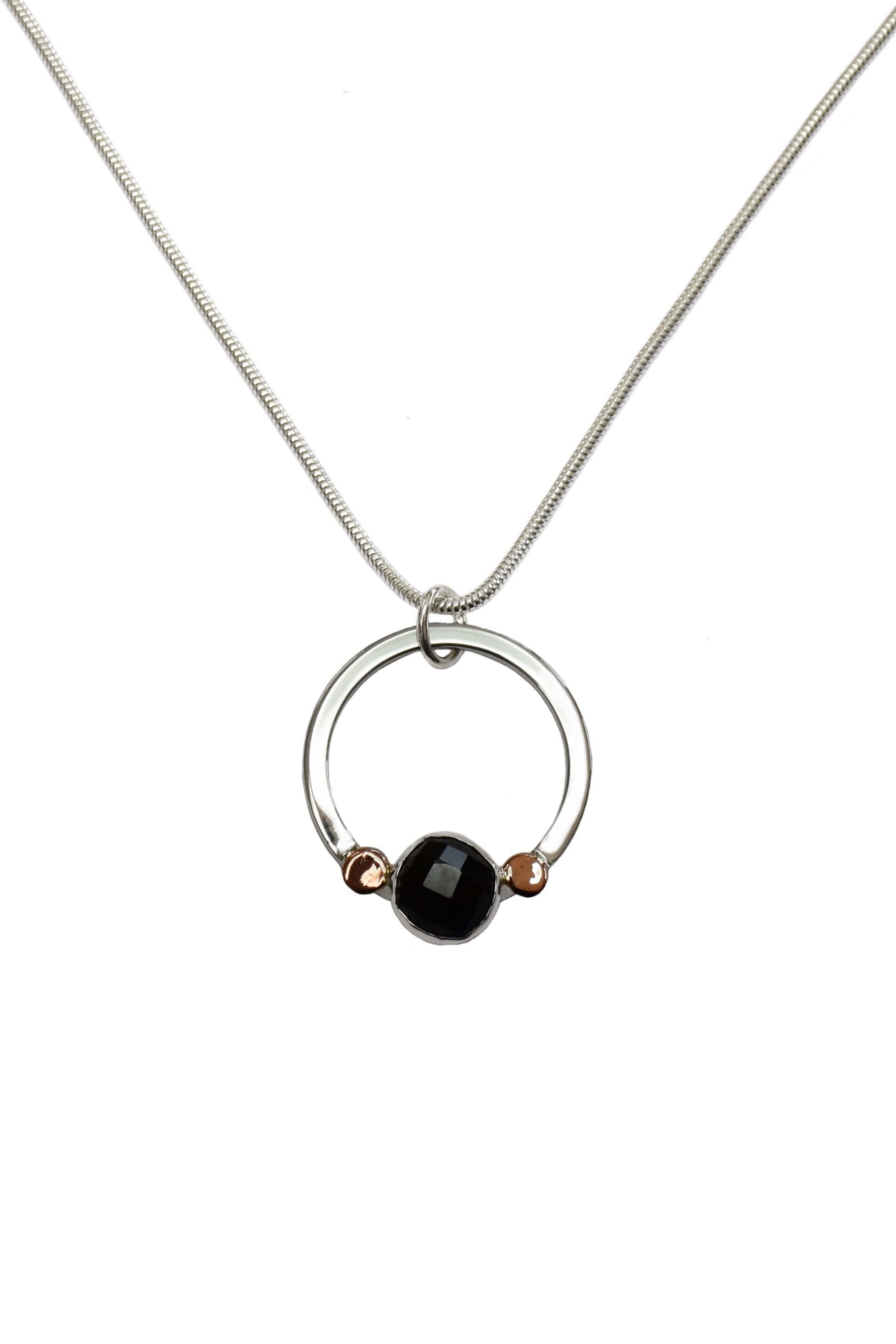 A handmade sterling silver black onyx pendant with rose gold pebbles.