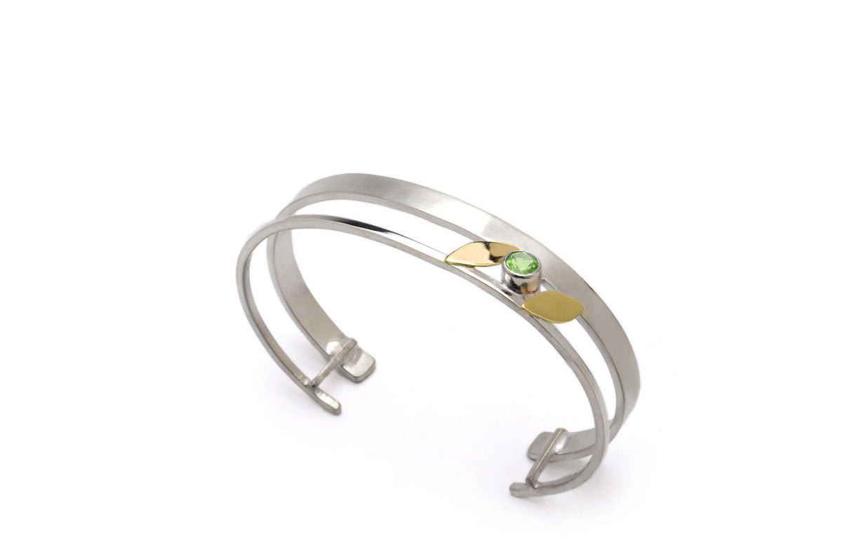 A sterling silver and gold leaf bracelet with peridot gemstone