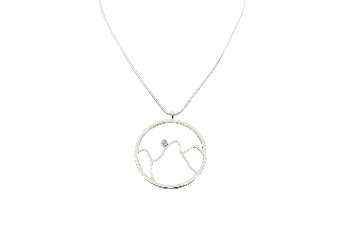 A handmade sterling silver mountain pendant necklace with cubic zirconia on silver chain