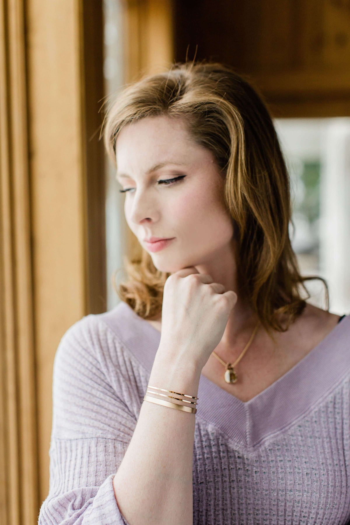 A model wears a handmade 14k gold cuff bracelet