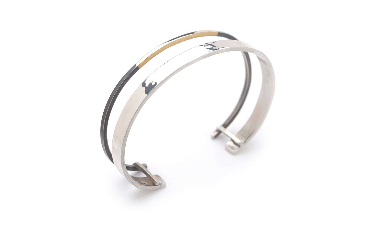 A handmade oxidized silver and gold jewelry cuff bracelet