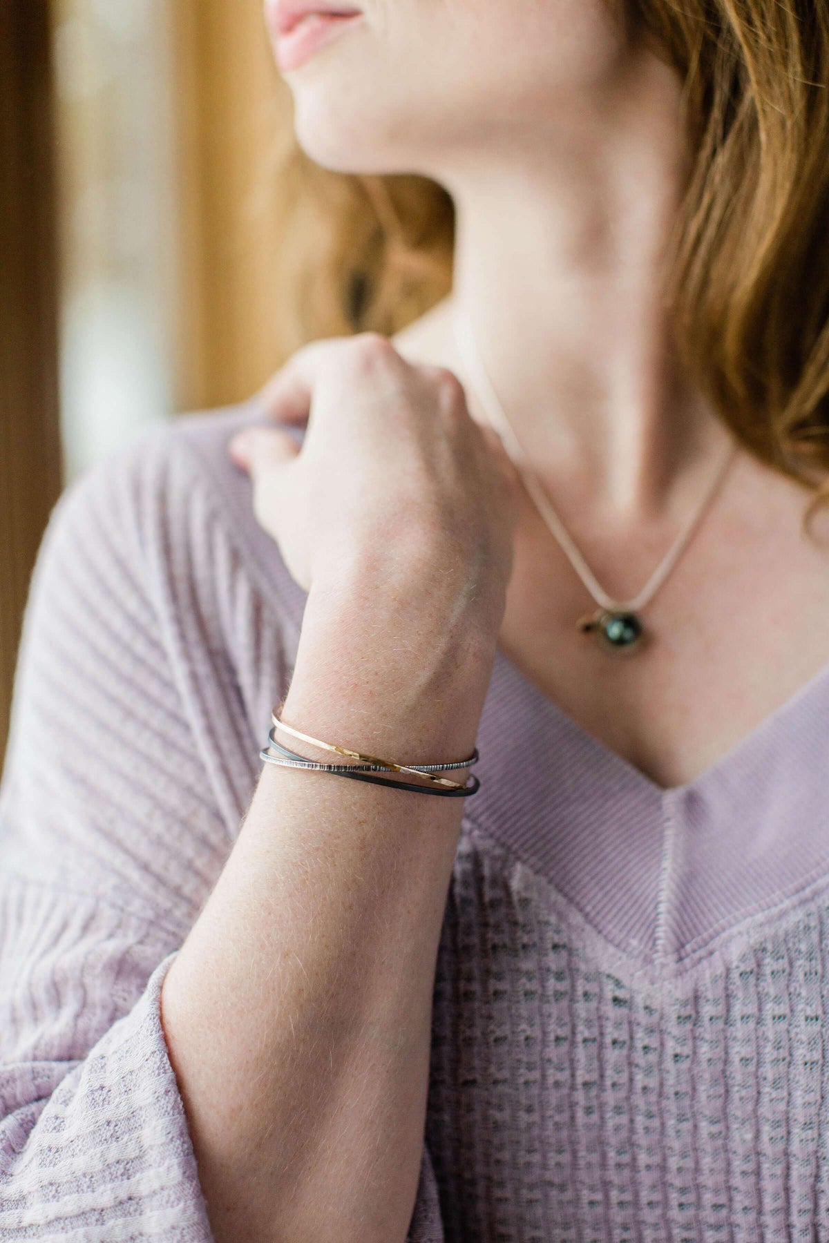 a model wears a handmade mixed metal cuff bracelet
