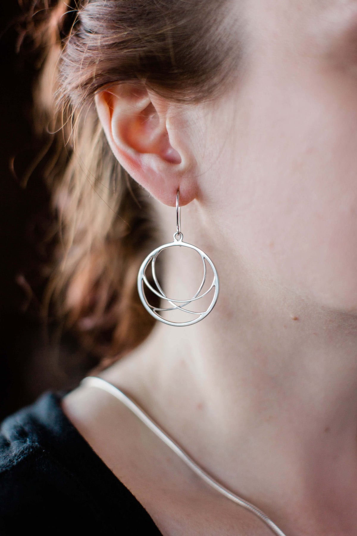 a model wears sterling silver woven hoop earrings