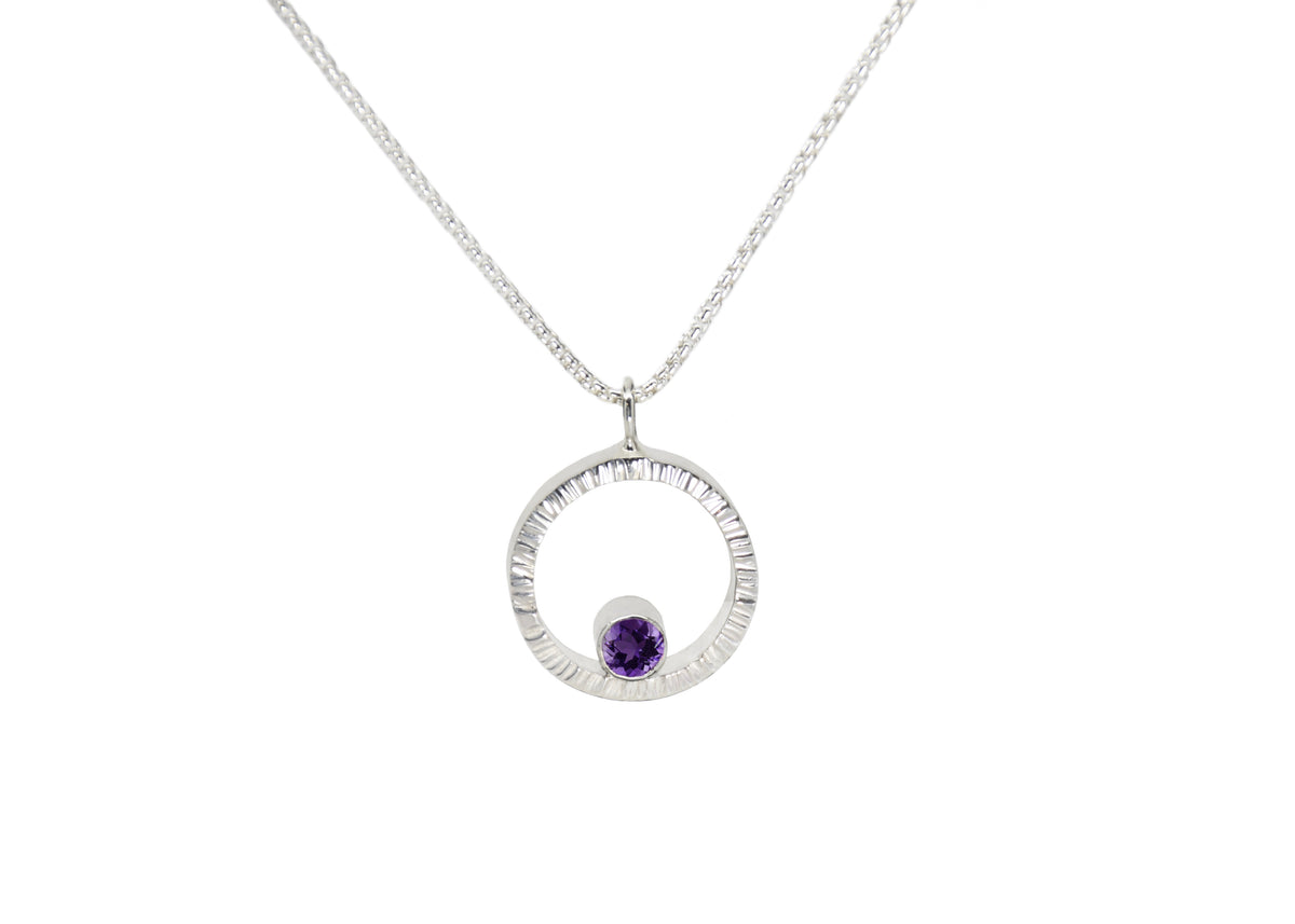 A sterling silver hammered circle pendant with amethyst